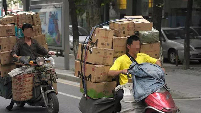 马路上骑着电动车的快递员